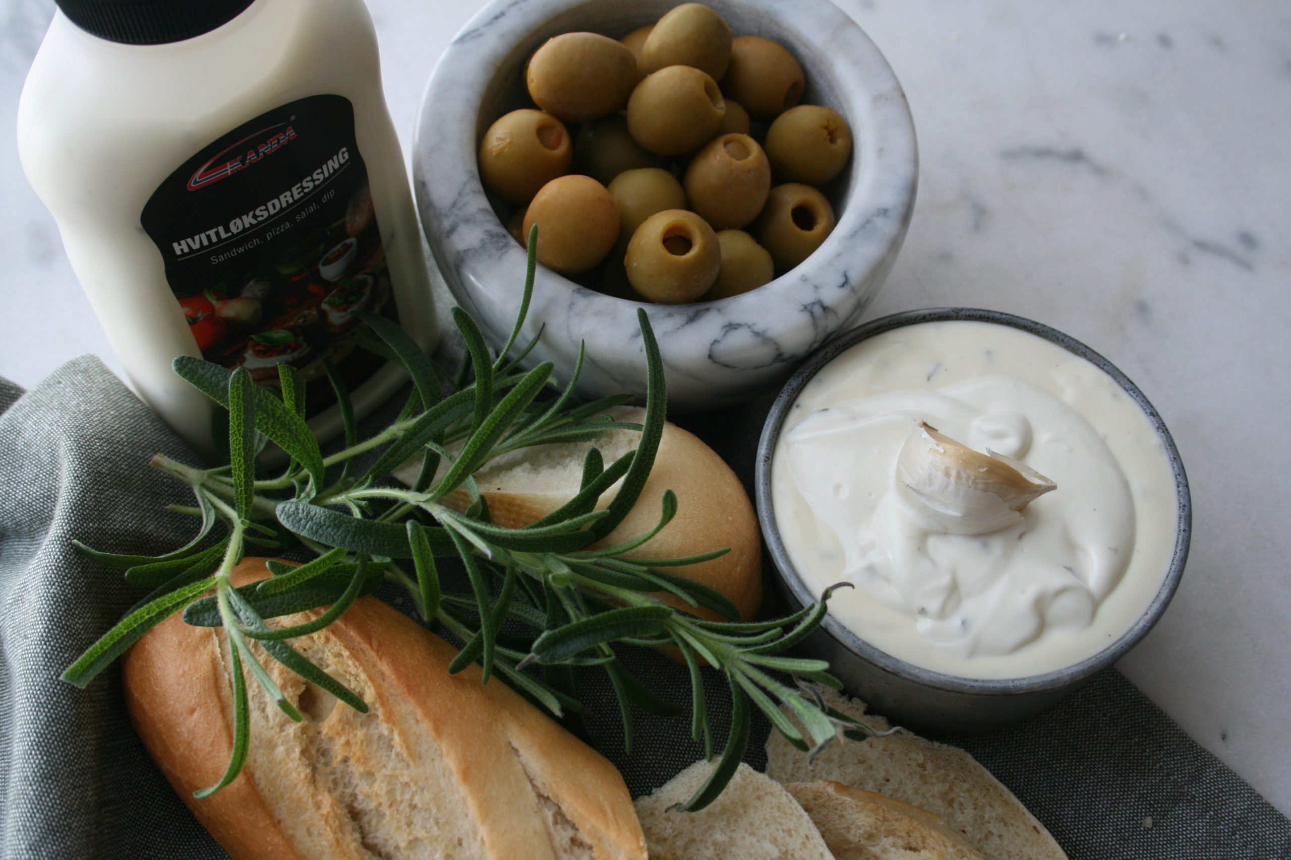 Hvitløksdressing og baguette med oliven